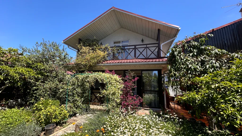 Дом с уютной верандой, выходящей в сад