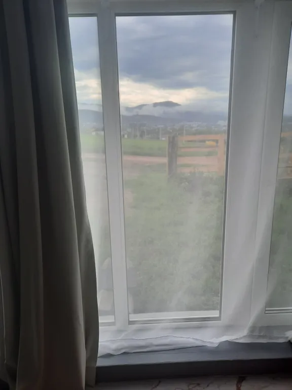 Комната с окнами в пол с видом на горы Белокурихи и город