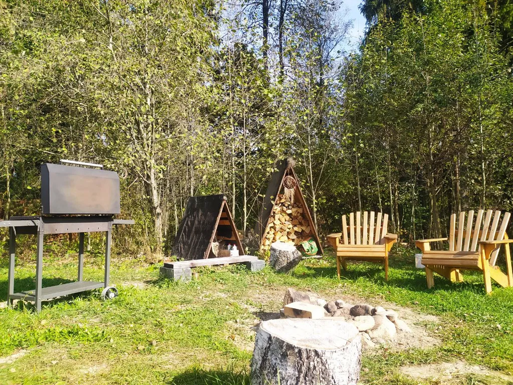 Лесной домик a-frame с террасой на холме, среди высоченных елей и берез