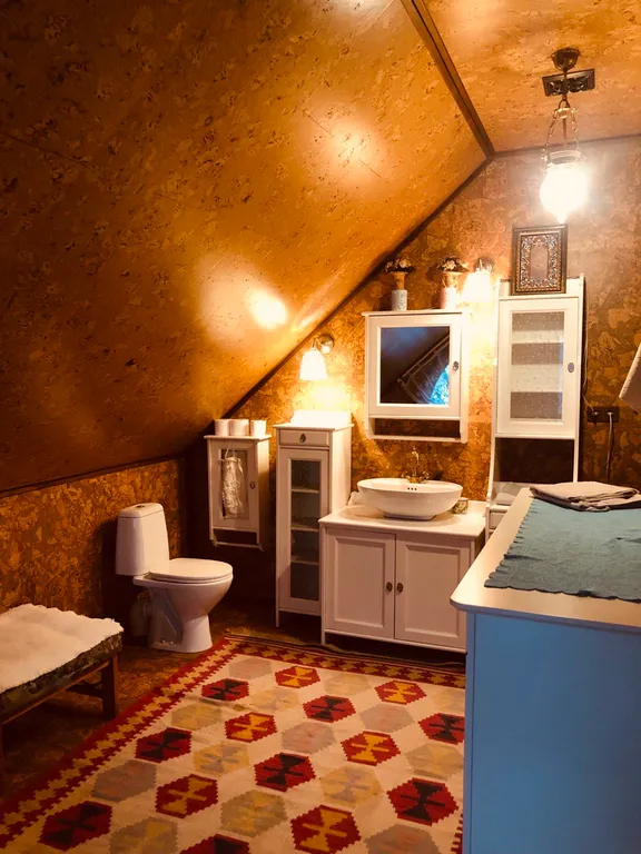 Изба (дом) из экологически чистого бревна под камышовой крышей в лесу