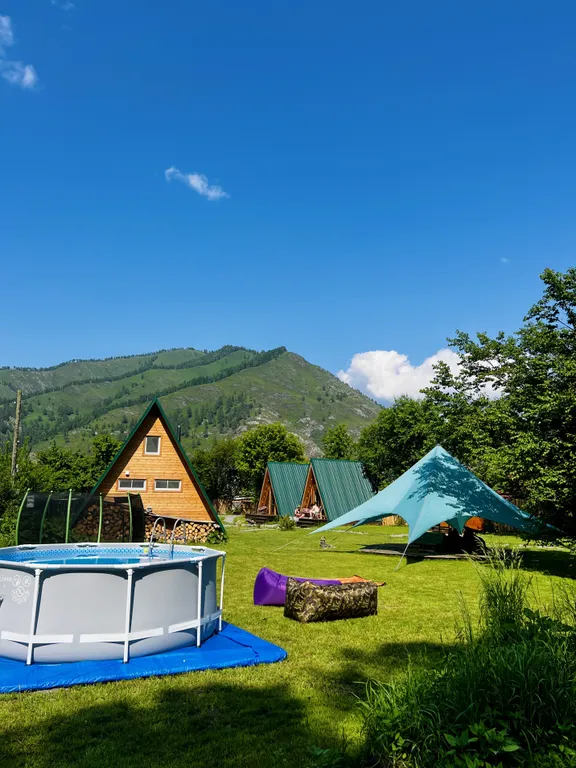 Уютный а-фрейм в сердце гор Алтая с видом на горы у леса