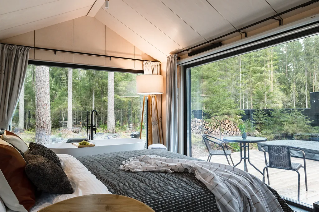 Дом с ванной у панорамного окна в хвойном лесу by Lynwood