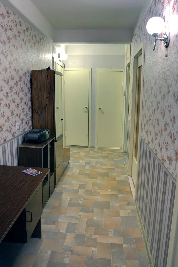 Вид на коридор из гостиной. Бра справа на стене включается шнурком. За дверью слева - кладовка со стиральной машиной, справа - туалет.  Письменный стол по желанию гостей можно переместить в одно из жилых помещений.