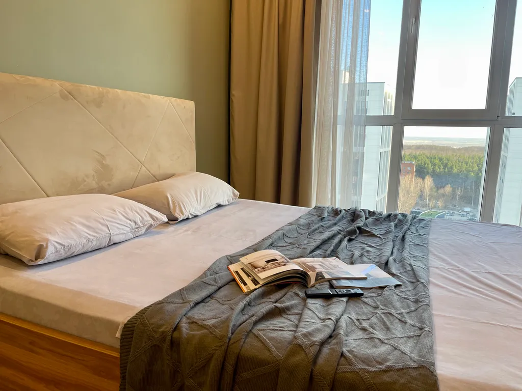 Новая квартира с кроватью возле панорамного окна, высокий этаж