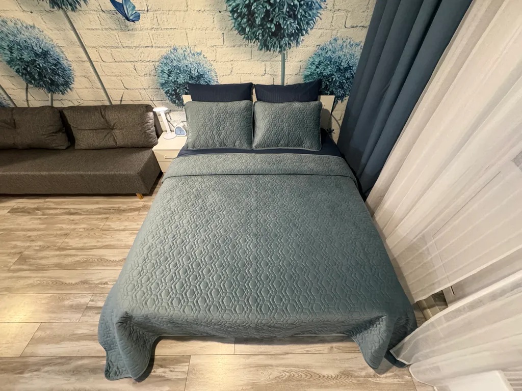 Уютная квартира-студия с большой кроватью и диваном