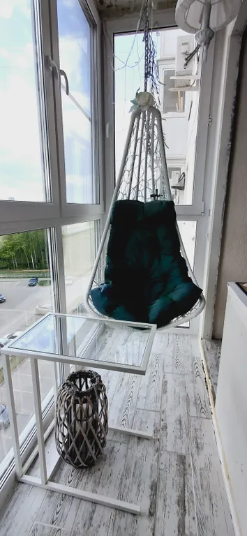 Квартира с подвесными креслами из ротанга на панорамной лоджии