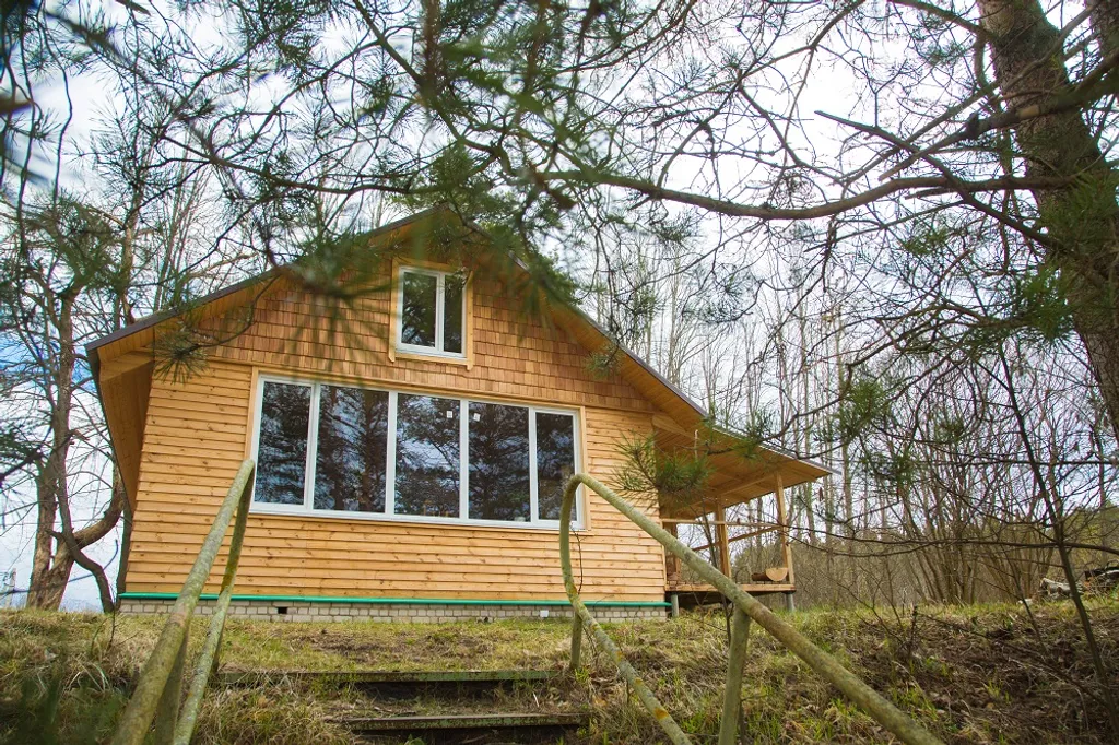 Жёлтый домик с панорамными окнами на берегу реки