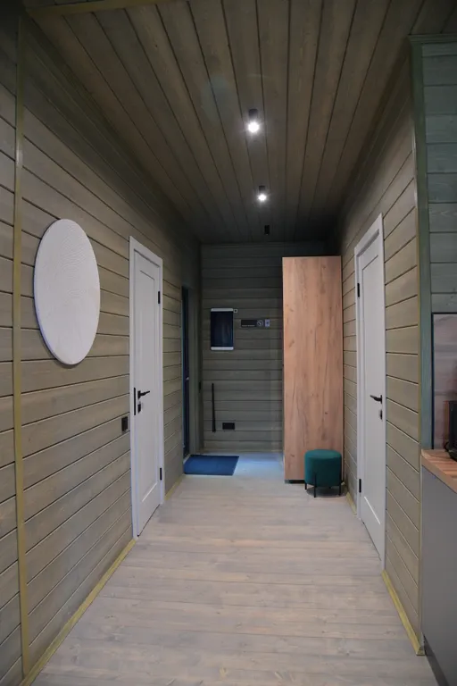 Дом с панорамными окнами в чаще леса у берега реки