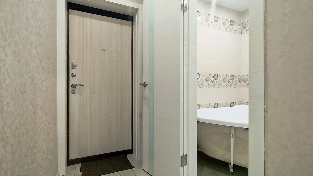 Уютная студия в тёплых тонах с большой угловой ванной для пары