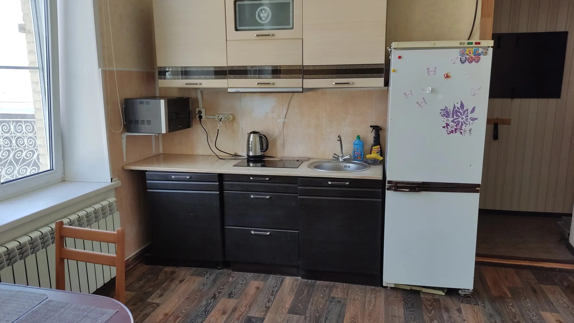 Кухонный уголок: СВЧ, чайник, электрическая печь, мойка, холодильник.