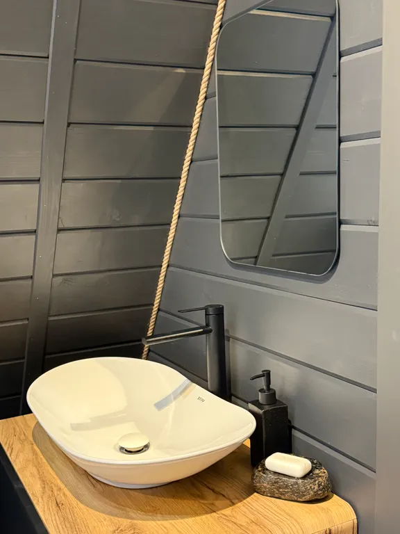 Большой треугольный домик с камином, с ванной у окна с видом на лес