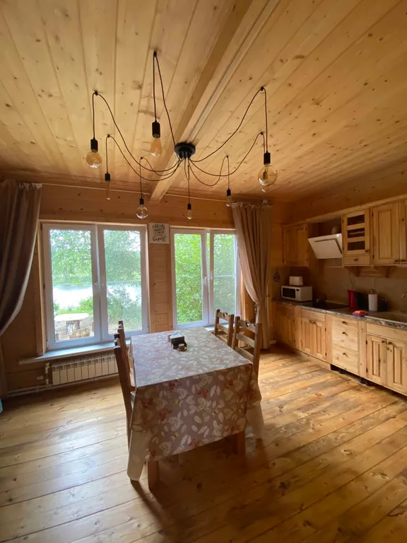 Деревянный дом на берегу реки с беседкой