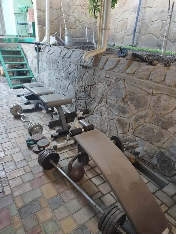 Часть дома с зелёной зоной отдыха во дворе и летней кухней