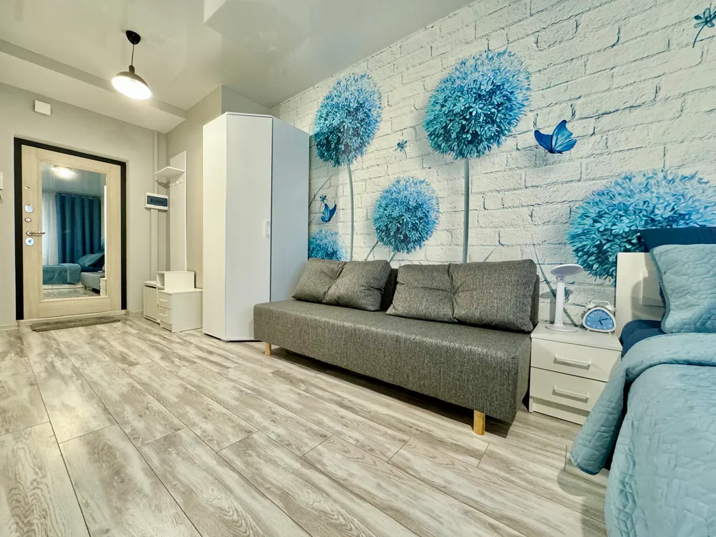 Уютная квартира-студия с большой кроватью и диваном