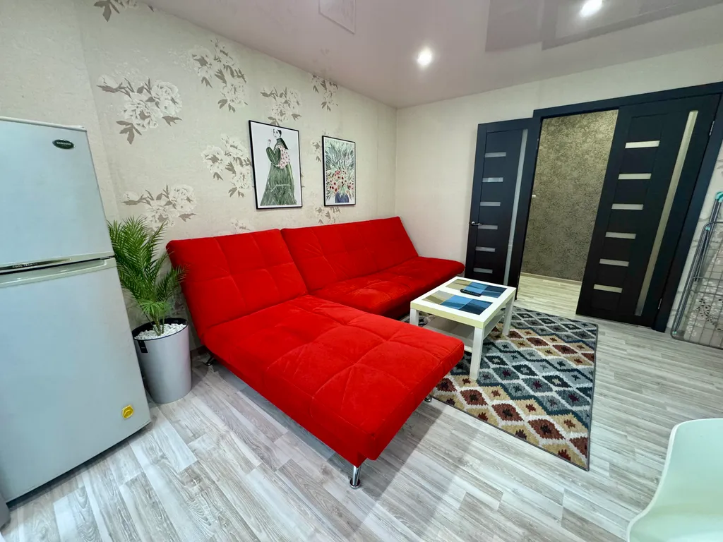 Двухкомнатная студия с красным диваном в центре города