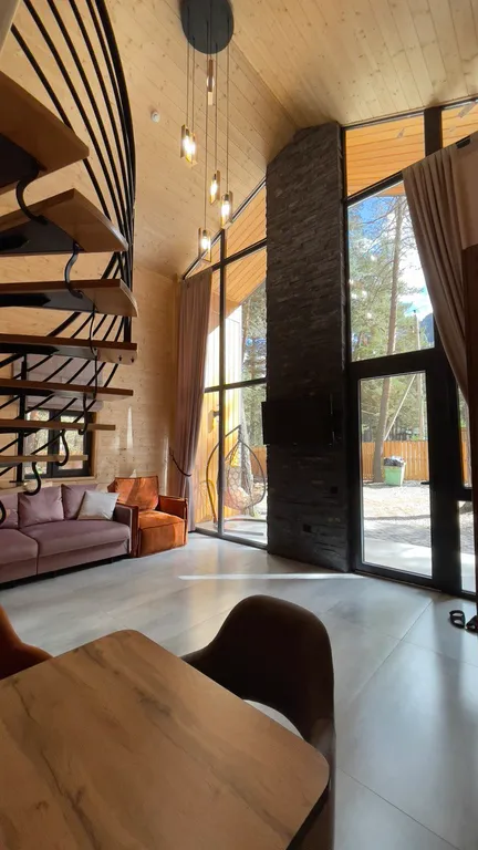 Двухуровневый дом с огромным витражным окном и видом на горы