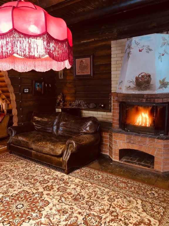 Изба (дом) из экологически чистого бревна под камышовой крышей в лесу