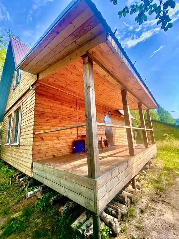 Деревянный дом на берегу реки с беседкой