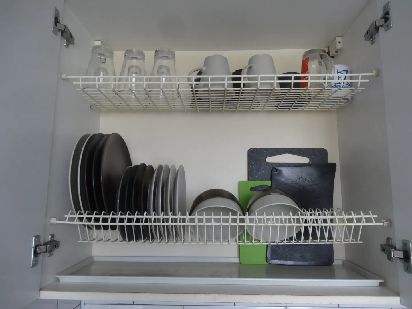 Тарелки, чашки, стаканы, разделочные доски хранятся в сушильном шкафу кухонного гарнитура над раковиной.