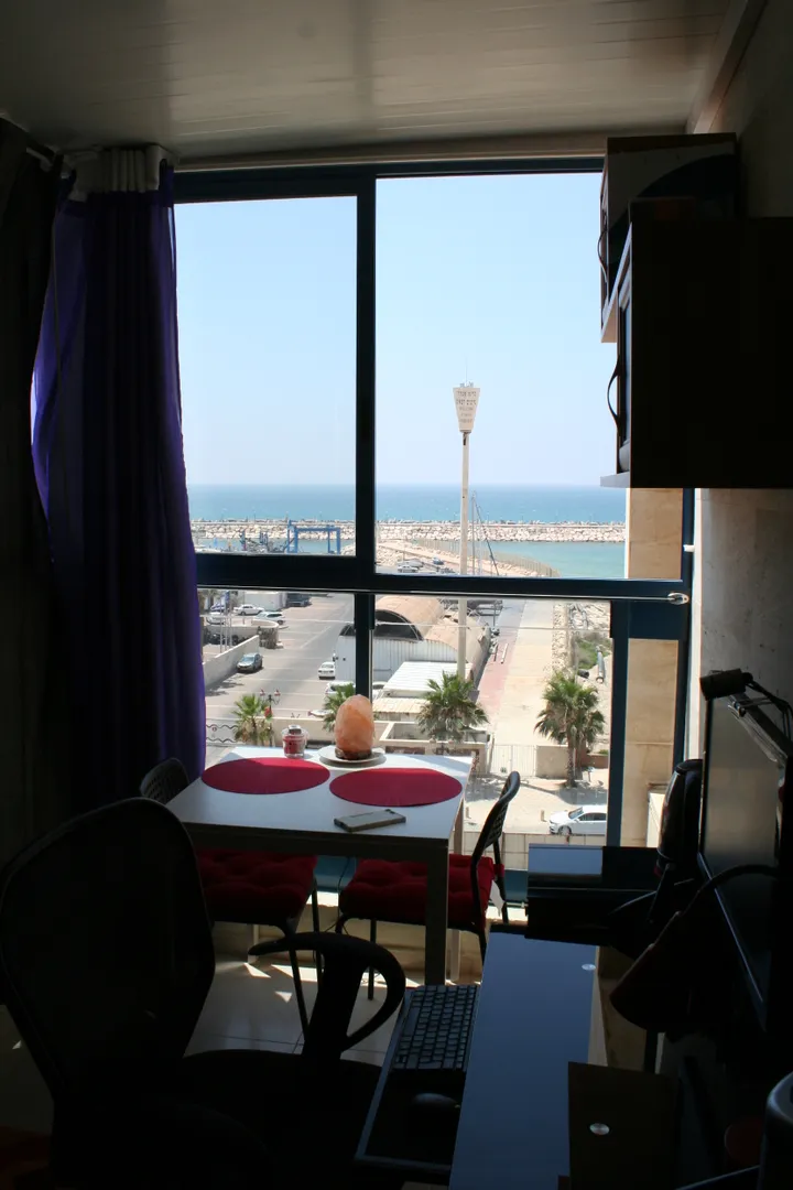 Закрытый балкон, рабочее место с компьютером и монитором, столик на двоих с видом на море
