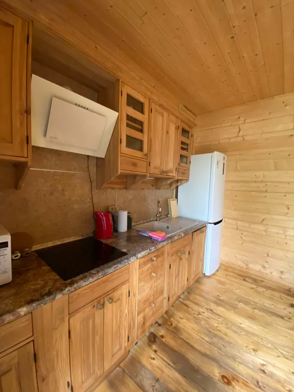 Деревянный дом на берегу реки с беседкой