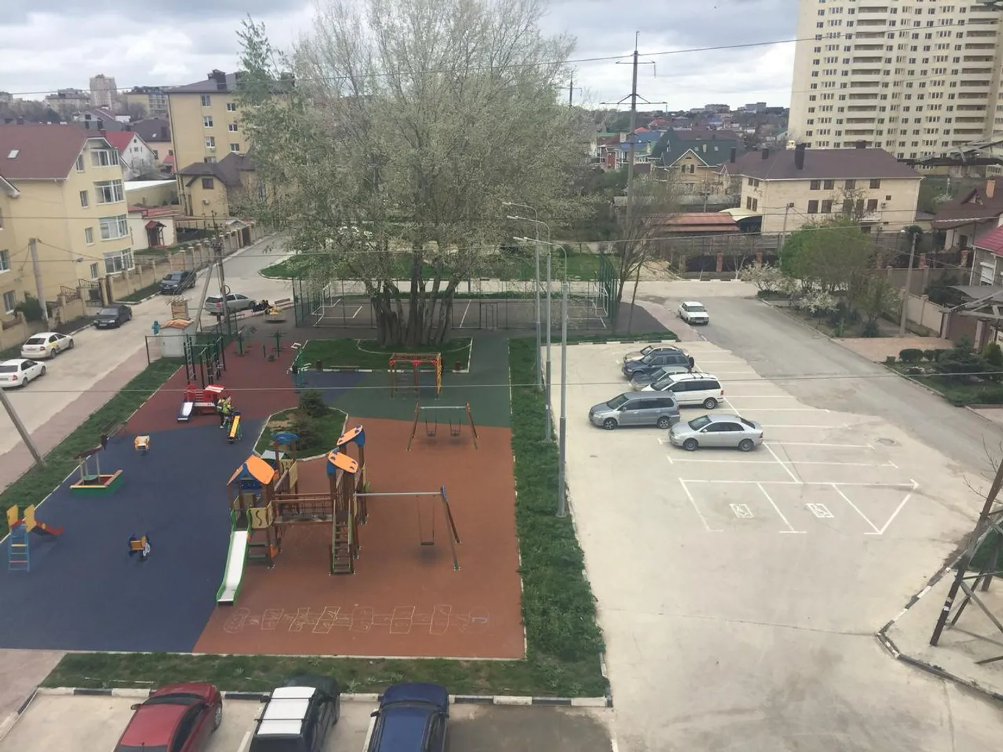 Вид на детскую площадку и парковку возле дома