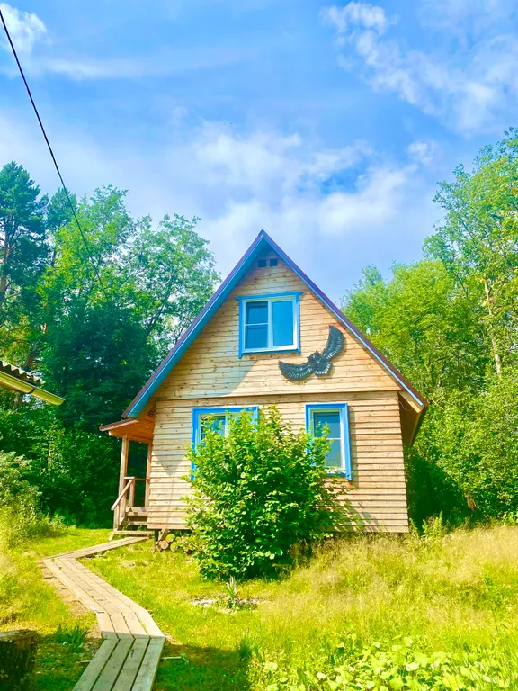 Деревянный дом на берегу реки с беседкой