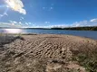 Это пляж. Чистый песок, пологий ровный заход в озеро. Он находится в 70 метрах от домика.