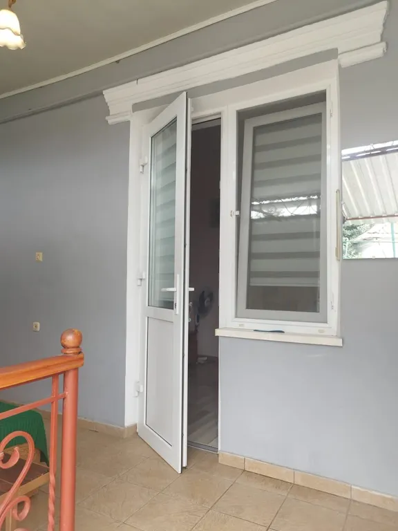 Часть дома с зелёной зоной отдыха во дворе и летней кухней