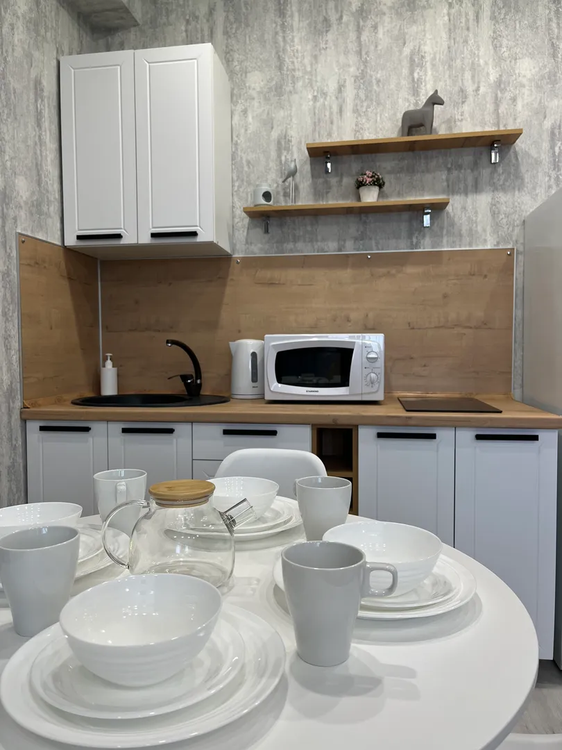 Кухонная зона полностью оборудована и имеет: плиту, микроволновую печь, чайник, холодильник.  