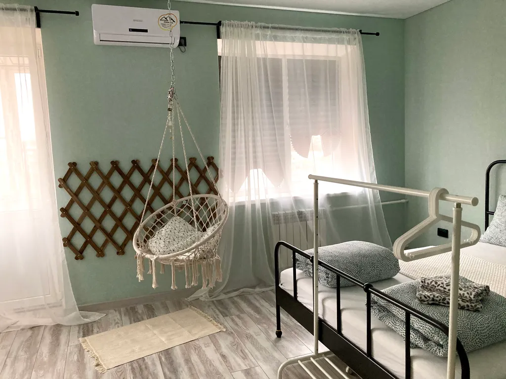 Уютная студия с качелями и видом на тихий зеленый сад