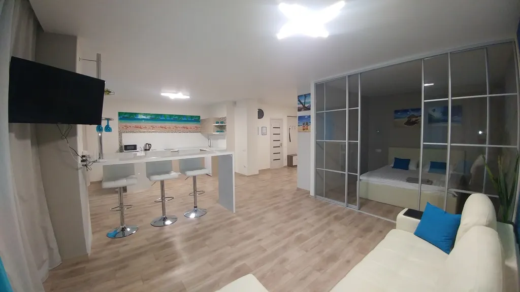 Светлая квартира- студия в голубых тонах с красивым видом на город