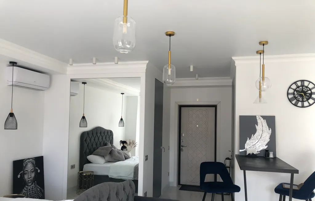 Стильная студия с ванной у панорамного окна и видом на горы