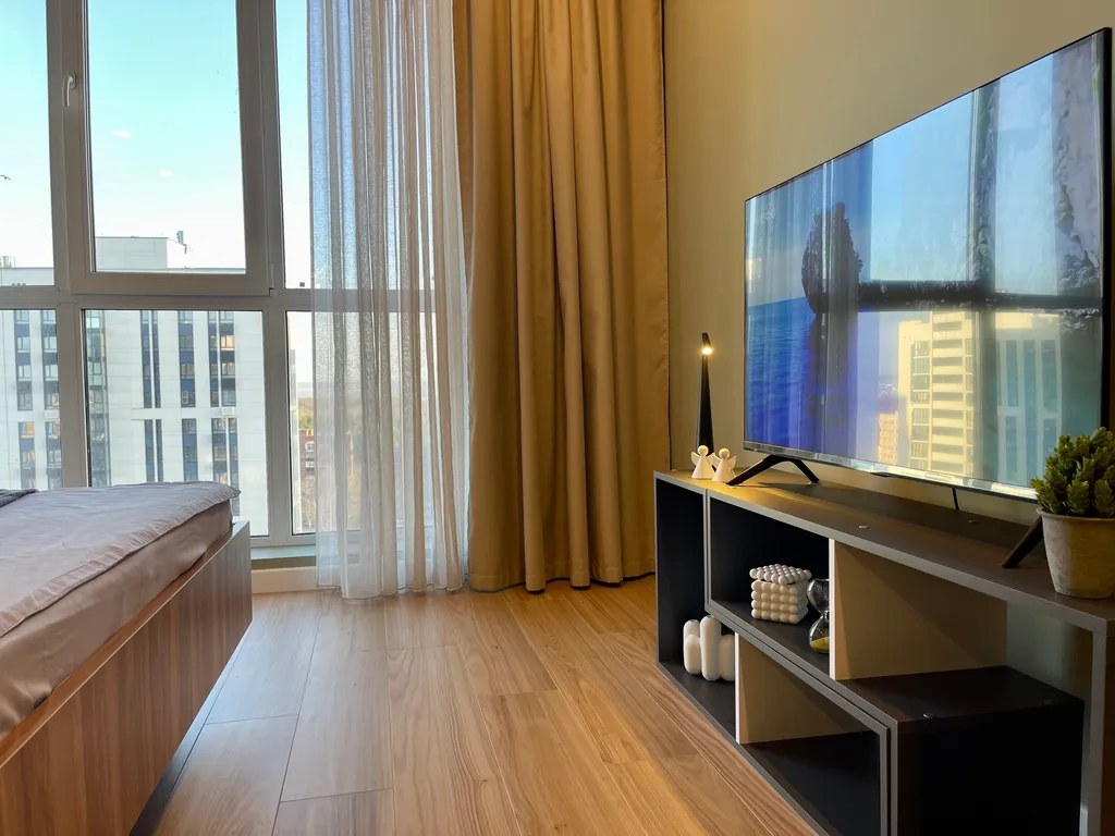 Новая квартира с кроватью возле панорамного окна, высокий этаж