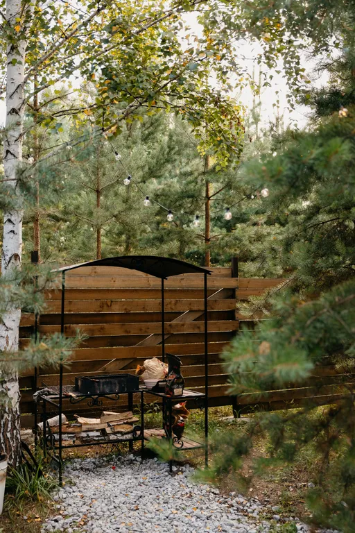 Дом с панорамными окнами и террасой в окружении леса