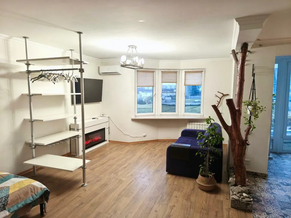 Студия с камином, деревом и видом на реку