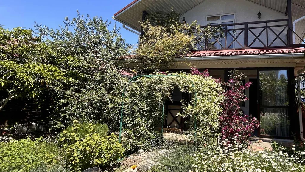 Дом с уютной верандой, выходящей в сад