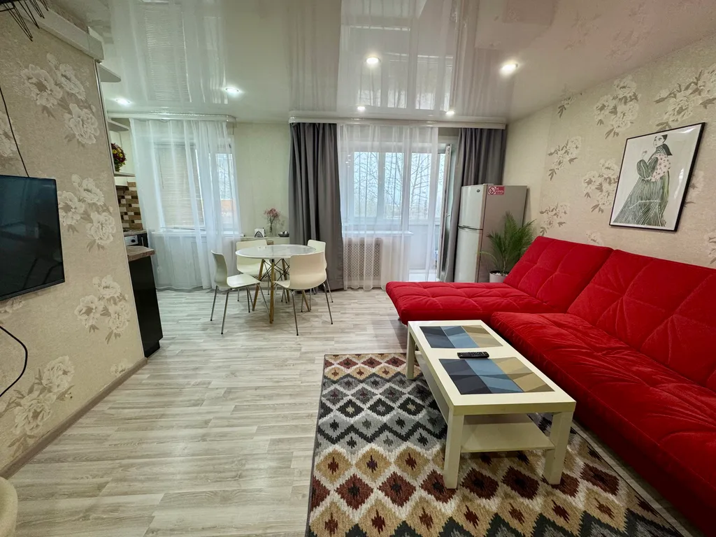 Двухкомнатная студия с красным диваном в центре города