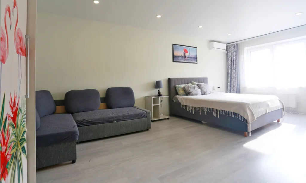 Уютная квартира в стиле лофт с комфортной кроватью и угловым диваном