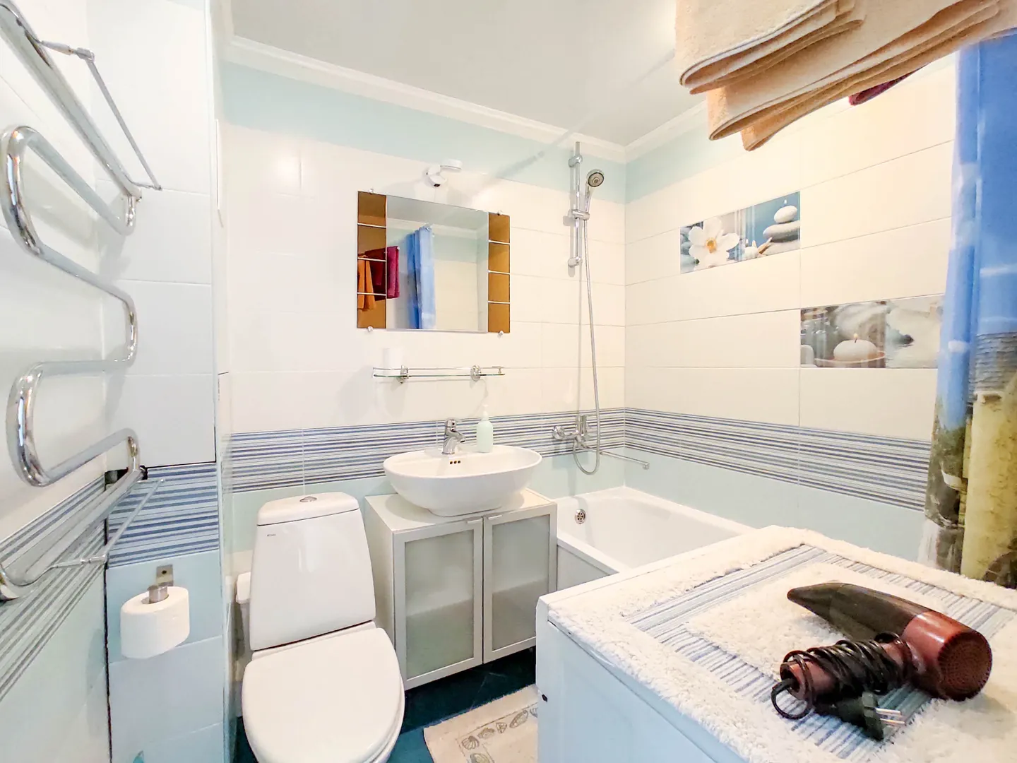 Ванная: стиральная машина, полотенца, фен, запас туалетной бумаги гигиенические принадлежности в шкафчике под раковиной