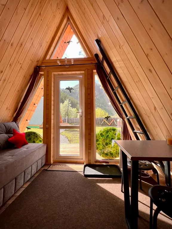 Уютный а-фрейм в сердце гор Алтая с видом на горы у леса