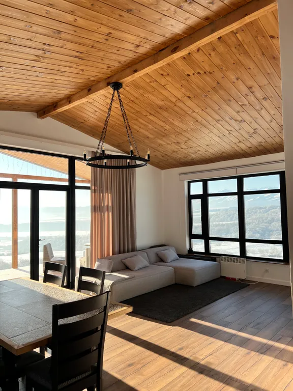 Домик на холме с видом на лес и горы