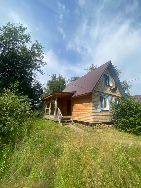 Деревянный дом на берегу реки с беседкой