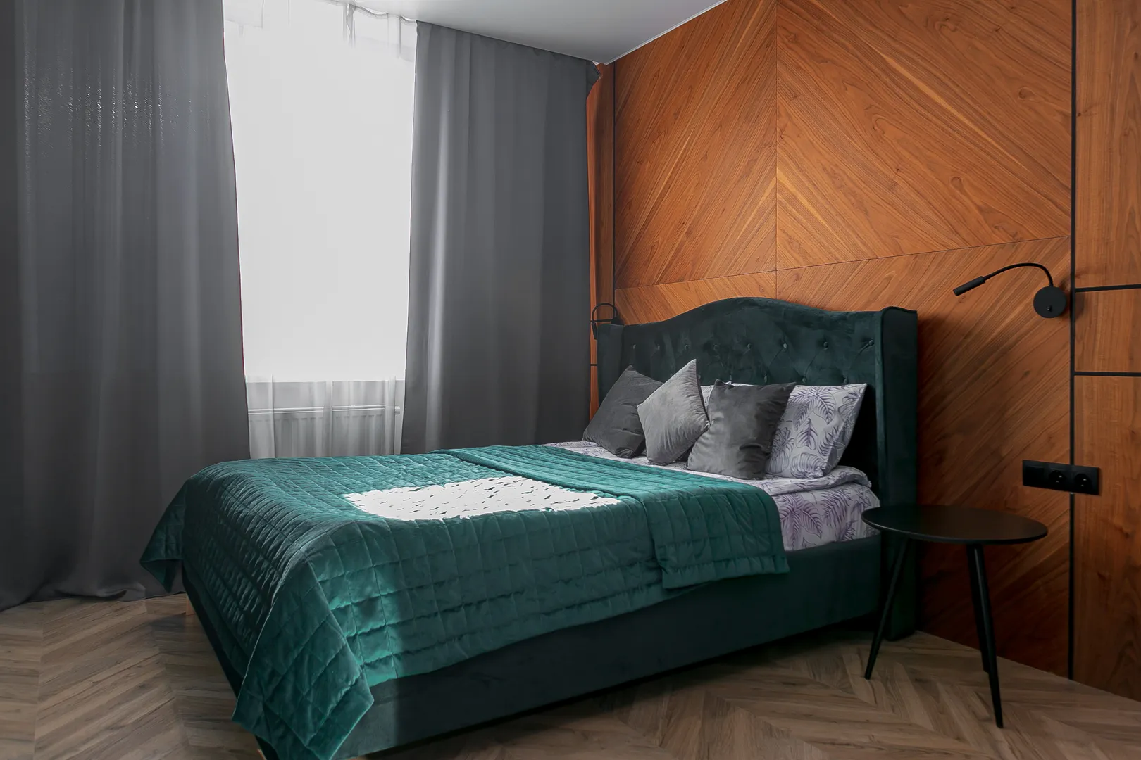 Двуспальная king-size кровать с прикроватным столиком и бра по обе стороны