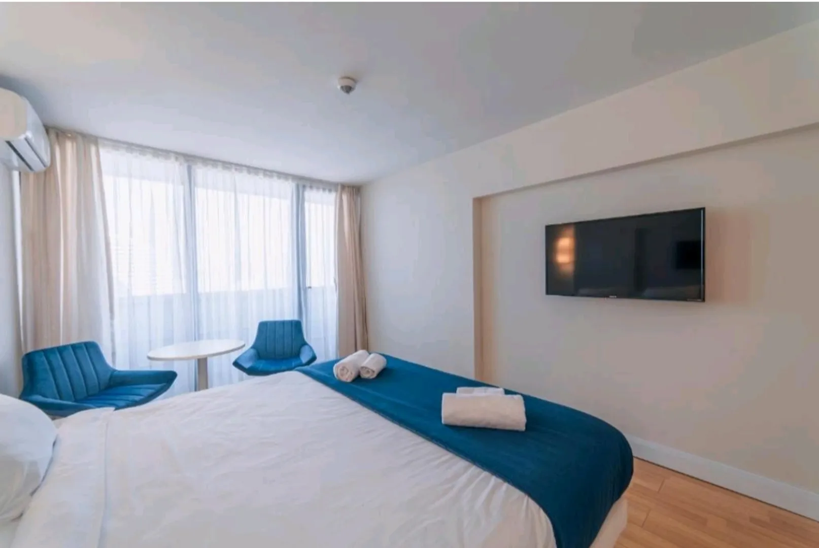 Современный плоский телевизор напротив кровати в нише стены апартаментов является очень актуальным для комфортного отдыха и времяпровождения.
