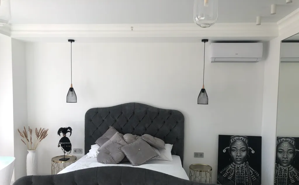 Стильная студия с ванной у панорамного окна и видом на горы