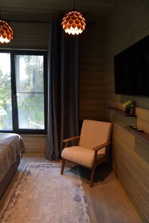 Дом с панорамными окнами в чаще леса у берега реки