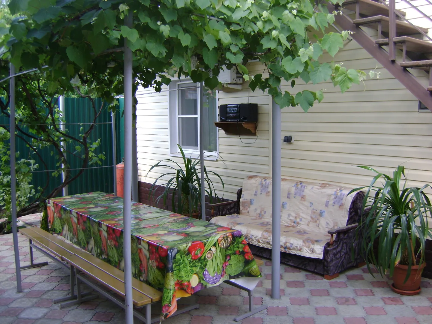 Стол под виноградником возле домика.