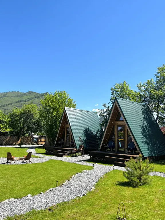 Уютный а-фрейм в сердце гор Алтая с видом на горы у леса