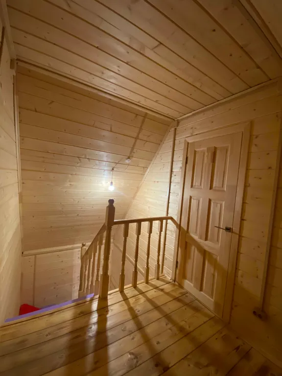 Деревянный дом на берегу реки с беседкой